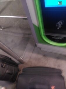 vor einem fahrkartenautomaten stehen zwei koffer